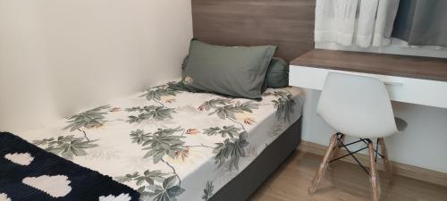 - un petit lit avec un oreiller et une chaise dans l'établissement BSDE 2BR Skyhouse Jervois, à Cilenggang