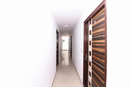 a hallway with wooden doors and white walls at Four Seasons in Sikandra