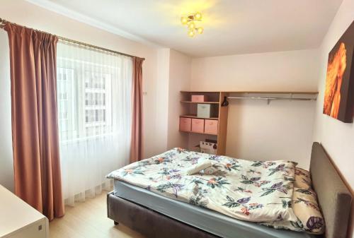 a bedroom with a bed with a floral bedspread at Select Apartment SIBIU in Sibiu