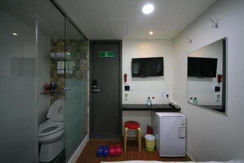 a bathroom with a shower and a toilet and a sink at Star Guest House in Seoul