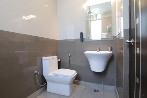 a bathroom with a toilet and a sink at Hotel Leaf 9, Cyber City near Ambience Mall in Gurgaon