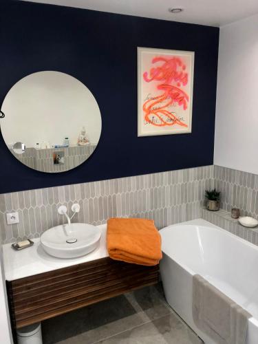 une salle de bain avec une baignoire, un lavabo et un miroir dans l'établissement Chambre dans Hôtel Particulier 18e siècle Hyper Centre La Rochelle, à La Rochelle
