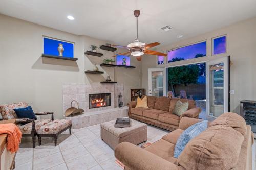 a living room with a couch and a fireplace at A Royal Oasis in the Desert with pool, spa and Epic Game Room! in Bermuda Dunes