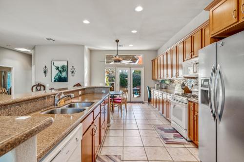 a kitchen with wooden cabinets and stainless steel appliances at A Royal Oasis in the Desert with pool, spa and Epic Game Room! in Bermuda Dunes