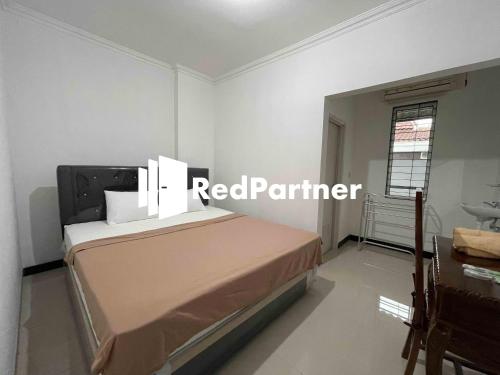 - une chambre avec un lit et un panneau de contour rouge dans l'établissement Hotel Pusponjolo Syariah Semarang Mitra RedDoorz, à Semarang