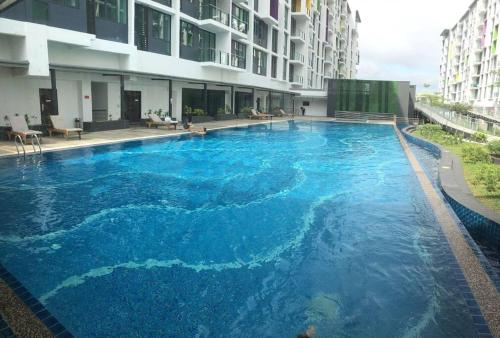 une grande piscine bleue au milieu d'un bâtiment dans l'établissement Jeff and Ricky Homestay 3 @Vivacity Megamall, à Kampong Tabuan