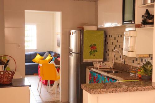 a kitchen with a refrigerator and a table with chairs at Casa de andar a 200m da areia Praia da Caueira SE in Praia Da Caueira