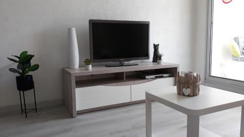 ein Wohnzimmer mit einem TV auf einem weißen Schrank in der Unterkunft Pin-Rolland - appartement 2 chambres à 400m de la plage in Saint-Mandrier-sur-Mer