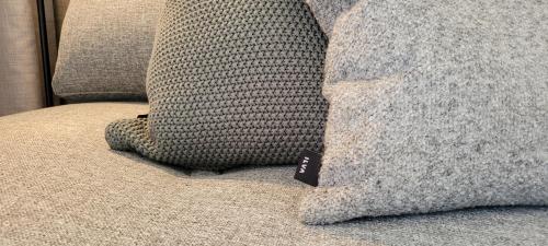 a pillow on a couch with a tag on it at Halmstad Golfarena Hotell & Lägenheter in Halmstad