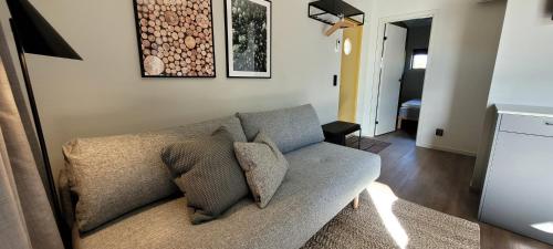 a living room with a couch with pillows on it at Halmstad Golfarena Hotell & Lägenheter in Halmstad
