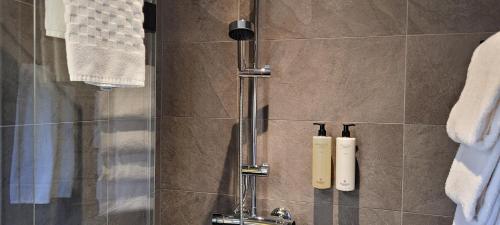 - Baño con ducha y 2 botellas en la pared en Halmstad Golfarena Hotell & Lägenheter en Halmstad