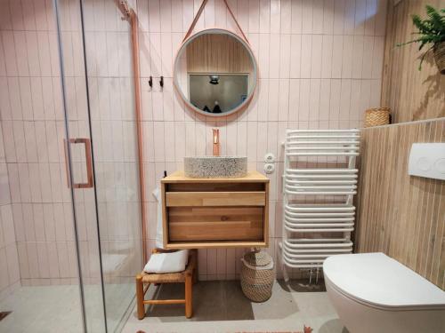 een badkamer met een wastafel, een toilet en een spiegel bij The Forest Lodge in Otterlo