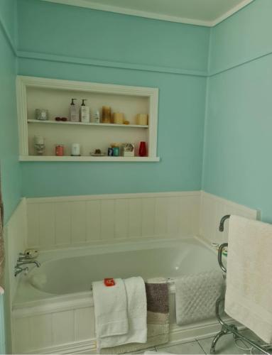 a bathroom with a bath tub with towels on it at Jo’s Farmhouse B&B in Geeveston