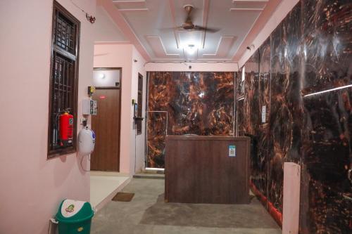 ein Badezimmer mit einer schwarzen Marmorwand mit einem Feuerlöscher in der Unterkunft Hotel O Hmi International in Meerut