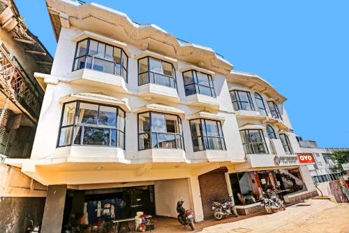 a white building with windows on a street at OYO Hotel Jayam Ooty Residency in Ooty