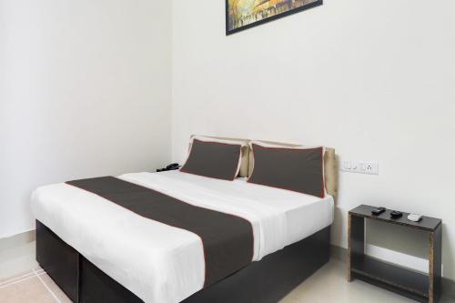 a bedroom with a large bed and a side table at Hotel Mk Grand in Patna