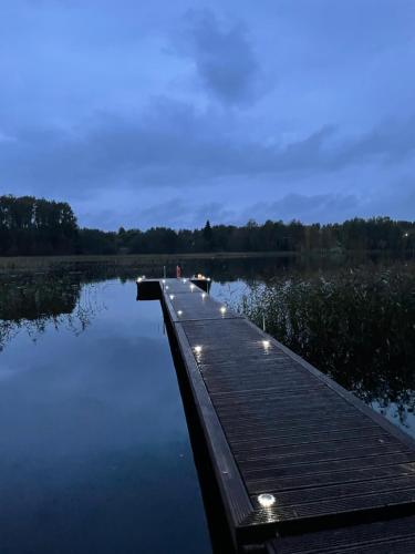 een dok op een meer met lichten erop bij Ieviņi atpūtas vieta 