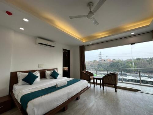 a bedroom with a large bed and a large window at Hotel The Imperio in New Delhi