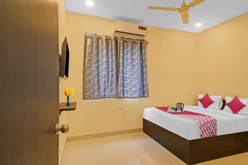 a bedroom with a bed and a window at OYO City Holiday in Surūrnagar
