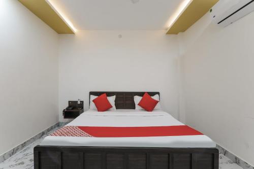 una camera da letto con un grande letto con cuscini rossi di OYO Hotel Aastha Near Chaudhary Charan Singh International Airport a Bijnaur