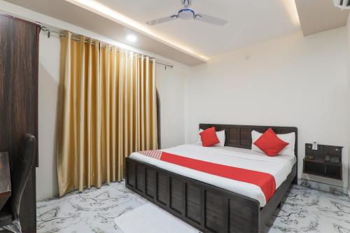 a bedroom with a bed with red pillows at OYO Hotel Aastha Near Chaudhary Charan Singh International Airport in Bijnaur