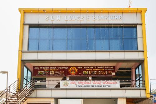 a building with a sign that reads sun house and something at Flagship Shree Raksha Comforts in Devanhalli