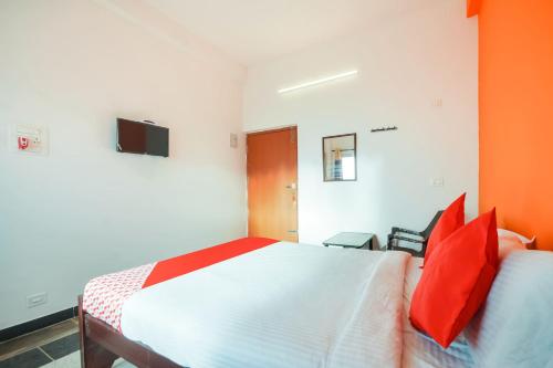 a bedroom with a large white bed with red pillows at Flagship New Cresent Park in Irugūr