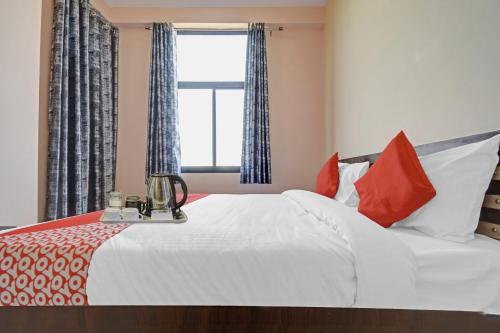 a bedroom with a large white bed with red pillows at OYO Flagship Hotel Kalot in Jaipur