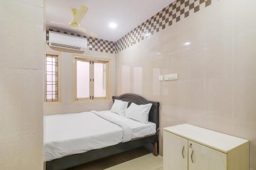 a small bedroom with a bed and a window at OYO Hotel Aroma Classic Near Nampally Railway station in Hyderabad