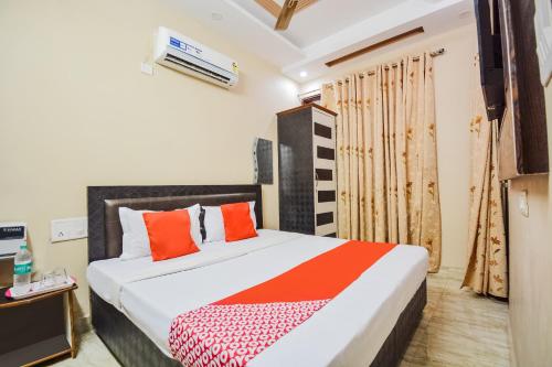 a bedroom with a large bed with orange pillows at OYO Orange Residency in Chik Bānavar