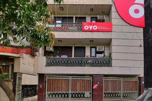 an apartment building with a balcony with a sign on it at OYO Capital O Hotel Lotus B&B in New Delhi