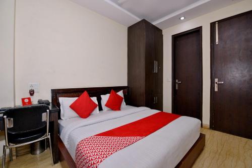 a bedroom with a large bed with red pillows at OYO Capital O Hotel Lotus B&B in New Delhi