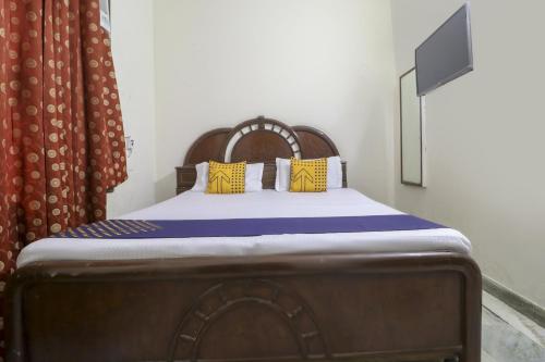 a bed with yellow and blue pillows in a room at SPOT ON Motel Haryana in Chandīgarh