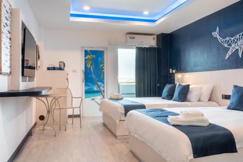 a hotel room with two beds and a table at Akira Pattaya in Jomtien Beach