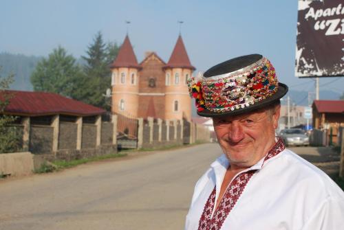 un homme portant un chapeau devant un bâtiment dans l'établissement Castle Belvedere, à Bukovel