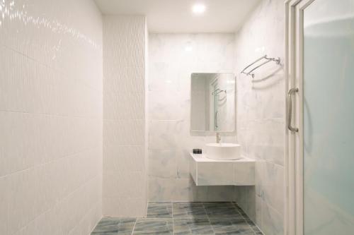 a white bathroom with a sink and a shower at Akira Pattaya in Jomtien Beach
