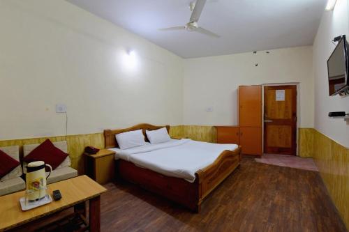 a bedroom with a bed and a couch in it at OYO Hotel Sunbeam in Shamshi