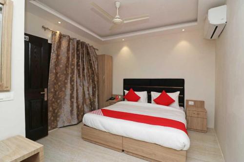 a bedroom with a large bed with red pillows at Shree Nanhu Hotel in Allahābād