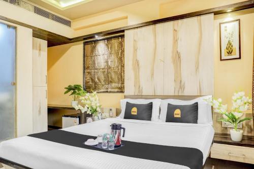 a bedroom with a large white bed with a table at Super Townhouse OAK Regal Inn Near Sant Tukaram Nagar Metro Station in Chinchiwad