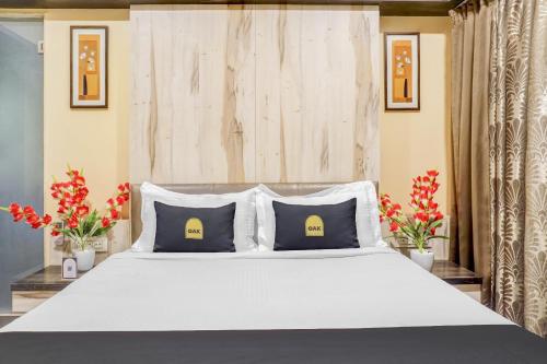 a bedroom with a large white bed with two pillows at Super Townhouse OAK Regal Inn Near Sant Tukaram Nagar Metro Station in Pune
