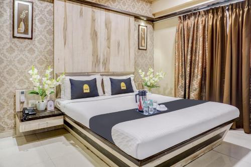 a bedroom with a large bed with blue pillows at Super Townhouse OAK Regal Inn Near Sant Tukaram Nagar Metro Station in Pune