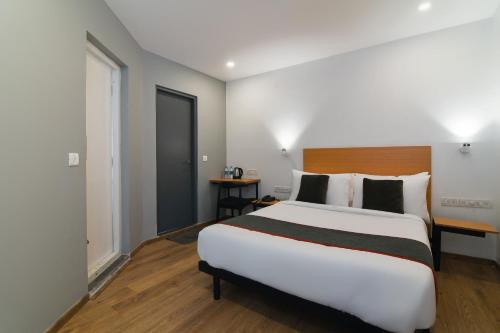 a bedroom with a large white bed and a window at Townhouse Spruce Hotels Bellandur in Bangalore