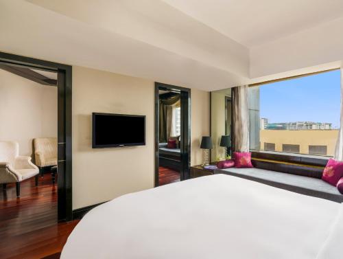 a hotel room with a large bed and a tv at Sofitel Mumbai BKC in Mumbai