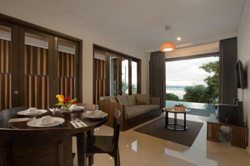 a living room with a table and a couch at Swiss-Belinn Luwuk in Luwuk