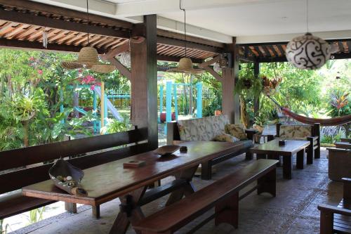 een restaurant met houten tafels, stoelen en planten bij VILA LUMAR in Coroa Vermelha