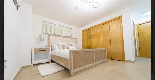 a bedroom with a bed and a wooden closet at Marbella Juan dolio beach front luxury apartment in Juan Dolio