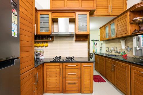 a kitchen with wooden cabinets and a sink at Paradise Inn in Cochin