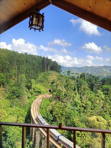 a train traveling down the tracks in the forest at Green Nature Paradise Ella in Ella