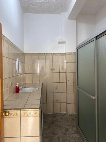 a bathroom with a sink and a shower at Casa en el Centro de Ilobasco in Nanastepeque