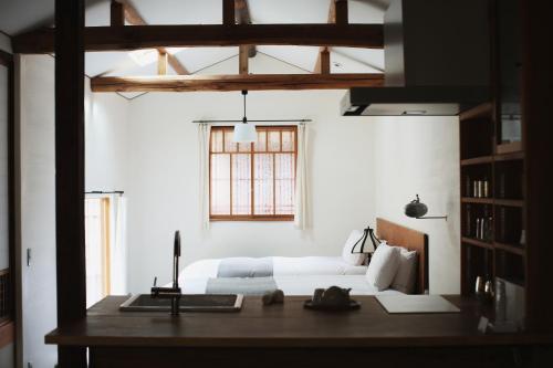 a bedroom with a bed and a desk and a window at 奈良町宿 紀寺の家 Naramachiyado Kidera no ie in Nara